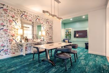 A room with a floral wallpaper and a white table with chairs.